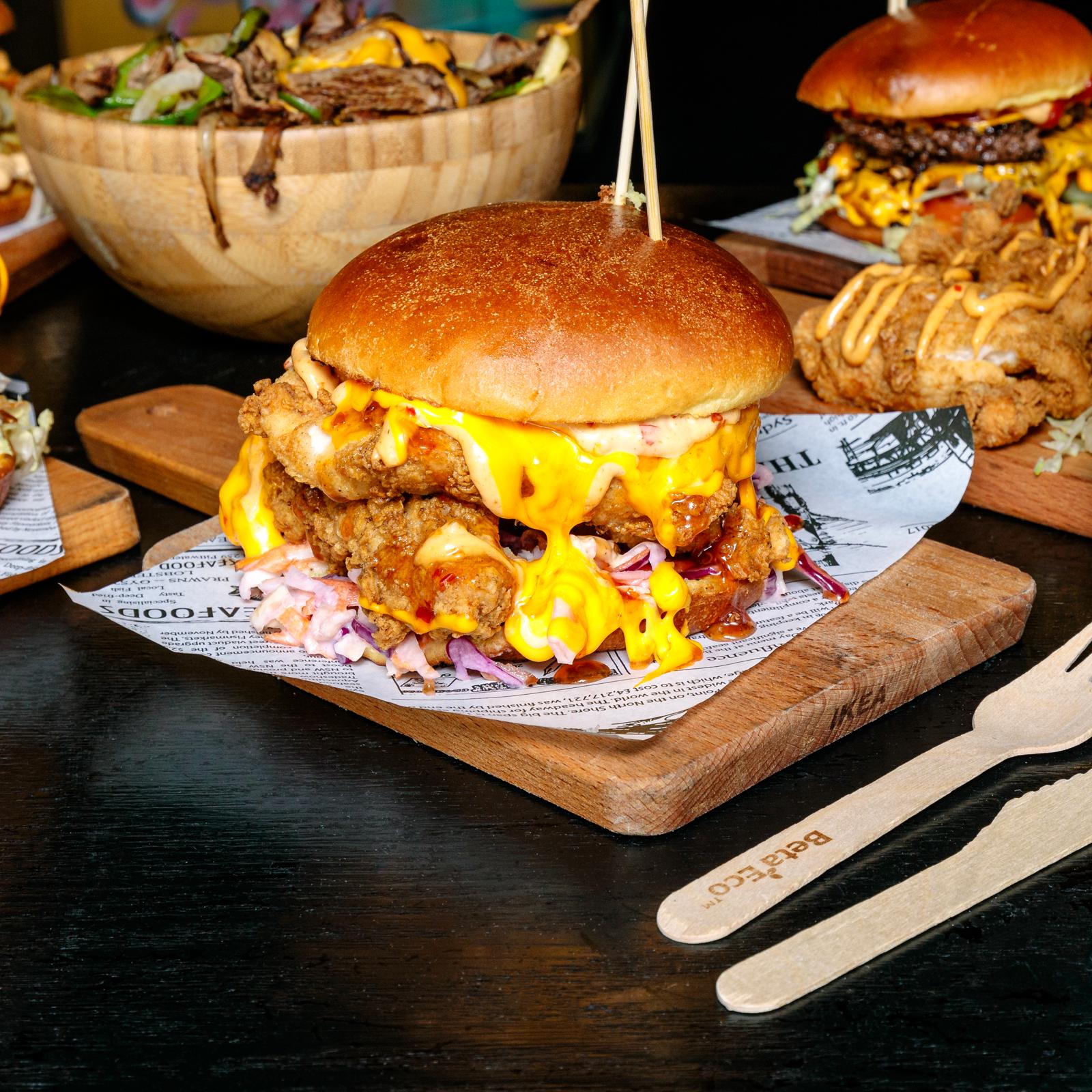 Loaded cheeseburger with slaw on a wooden board